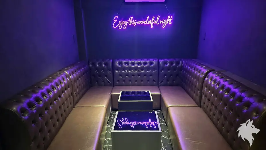 네온사인이 걸린 보라색 소파 좌석